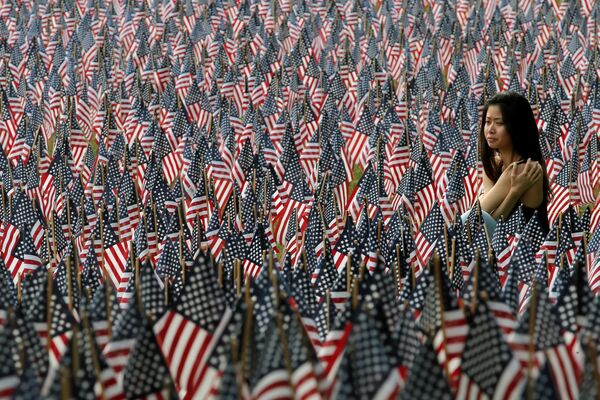 Женщина сидит на крою поля флагов США в штате Массачусетс - Sputnik Литва