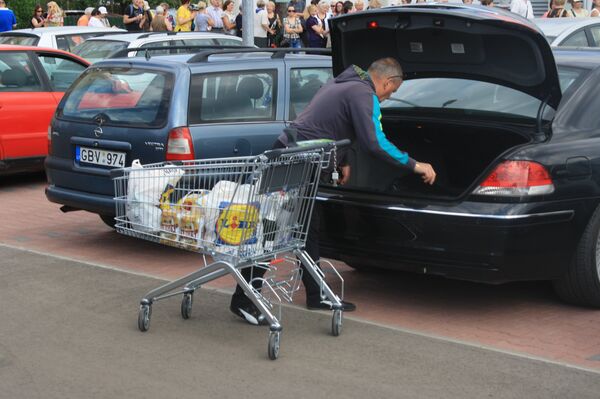 Первые посетители загружают покупки в автомобиль Первые посетители загружают покупки в автомобиль - Sputnik Литва