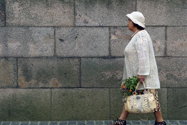 Пожилая женщина с букетом идет в костел - Sputnik Lietuva