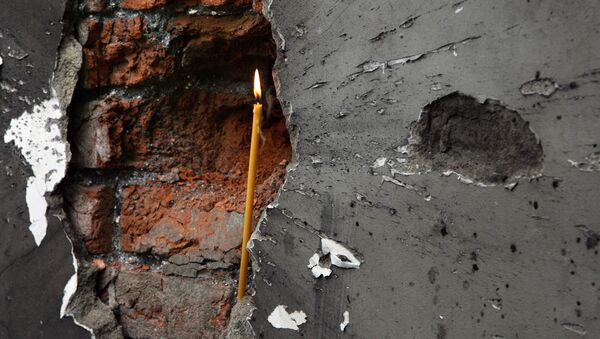 Свеча в воронке от взрыва стены в школе Беслана 10 сентбря 2004 года - Sputnik Литва