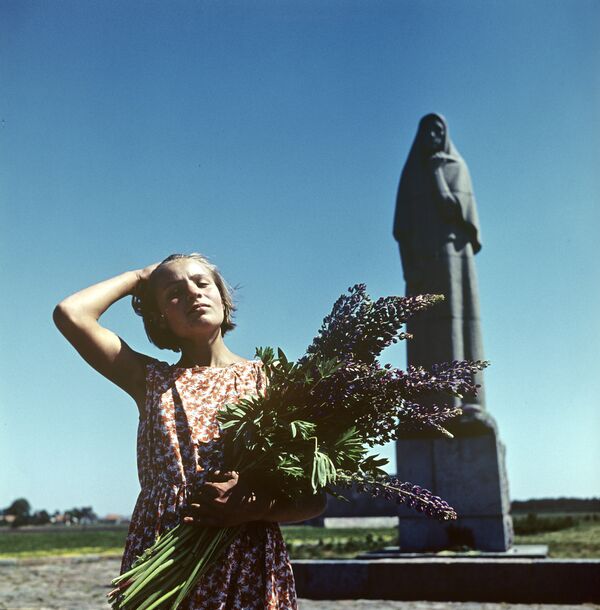 Девушка с цветами около памятника - Sputnik Lietuva