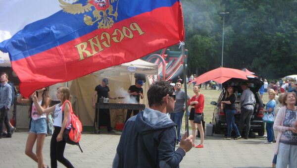 Мужчина несет флаг Российской Федерации на Дне России в Литве - Sputnik Lietuva