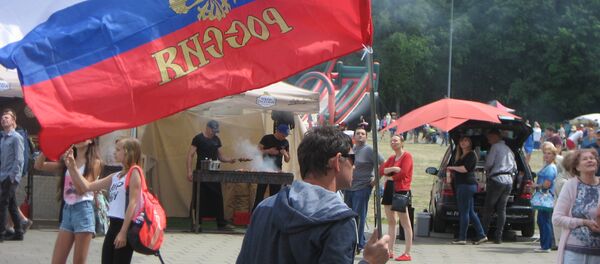 Мужчина несет флаг Российской Федерации на Дне России в Литве - Sputnik Литва