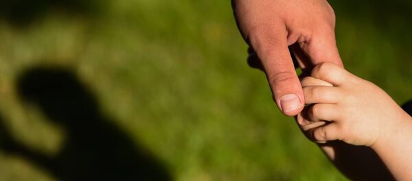 Мужчина держит за руку ребенка - Sputnik Литва