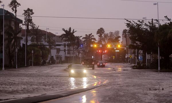 Автомобиль едет по затопленным улицам города Неаполь, штат Флорида. - Sputnik Литва