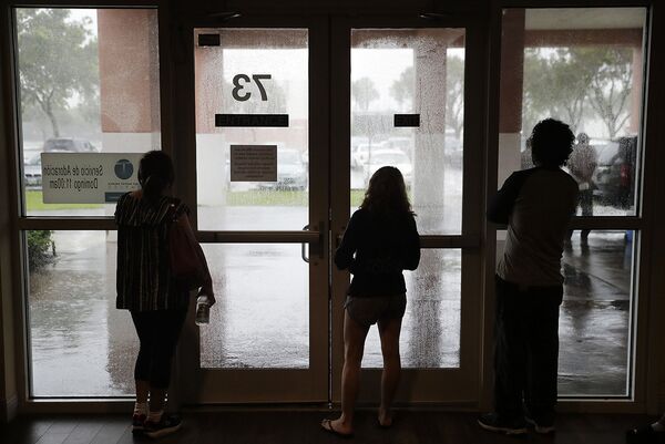 Эвакуированные жители Неаполя, штат Флорида, смотрят на буйство урагана из укрытия. - Sputnik Литва