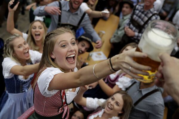 Молодая женщина борется за пиво во время открытия 184-го фестиваля пива Октоберфест в Мюнхене, Германия. - Sputnik Литва