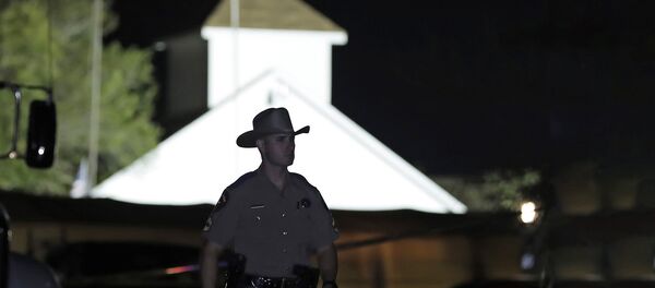 Полицейский на фоне баптистской церкви Сазерленд- Спрингс, где 5 ноября во время стрельбы погибли люди - Sputnik Lietuva