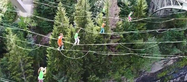 В Швейцарии экстремалы устроили танцы на канатах, натянутых между двумя мостами В Швейцарии экстремалы устроили танцы на канатах, натянутых между двумя мостами - Sputnik Lietuva