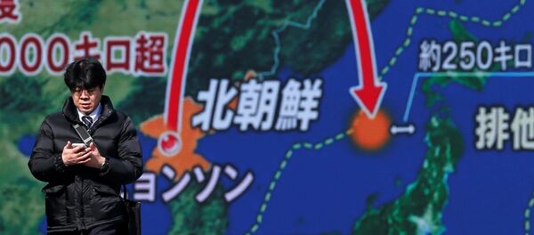 Мужчина около монитора, показывающего запуск межконтинентальной баллистической ракеты в Северной Корее - Sputnik Литва