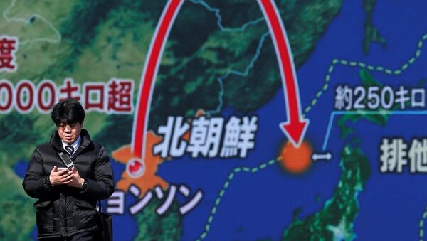 Мужчина около монитора, показывающего запуск межконтинентальной баллистической ракеты в Северной Корее - Sputnik Литва