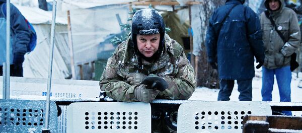 Протестующий стоит за баррикадой рядом со зданием парламента в Киеве - Sputnik Литва