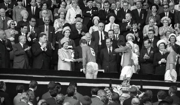 Королева Англии Елизавета II вручает приз VIII первенства мира по футболу Кубок Золотая богиня капитану английской сборной Роберту (Бобби) Муру - Sputnik Литва