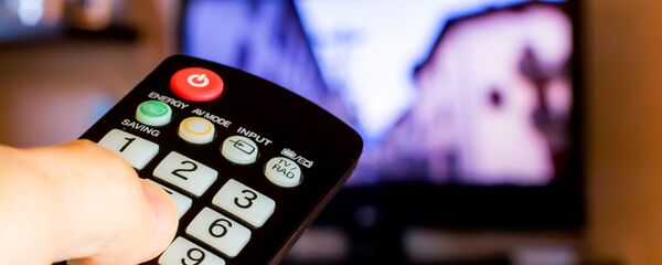 Рука с пультом напротив телевизора, архивное фото - Sputnik Литва