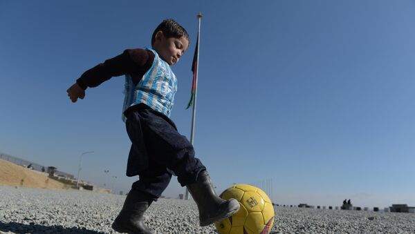Молодой фанат Лионеля Месси, Муртаза Ахмади, играет в футбол в Кабуле 1 февраля 2016 года - Sputnik Литва