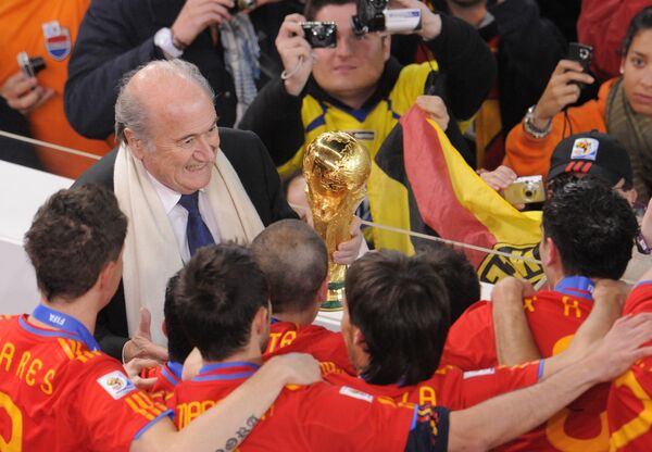 Президент ФИФА Зепп Блаттер вручает Кубок мира по футболу триумфаторам турнира в ЮАР – национальной команде Испании, победившей в финальном матче сборную Голландии - Sputnik Литва