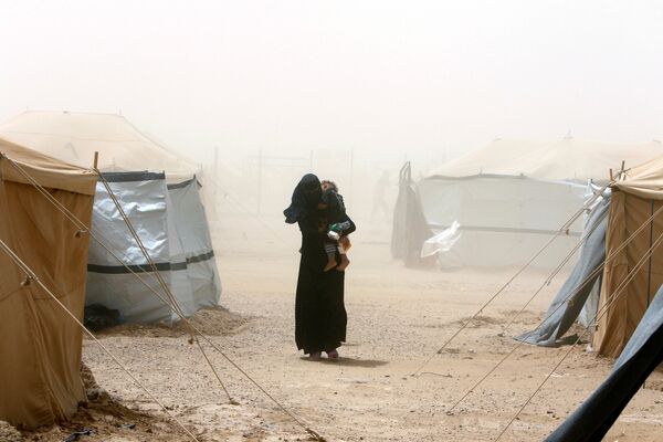 Женщина, бежавшая от насилия властей исламского государства, во время пылевой бури в лагере беженцев в Эль-Фаллудже, Ирак - Sputnik Литва