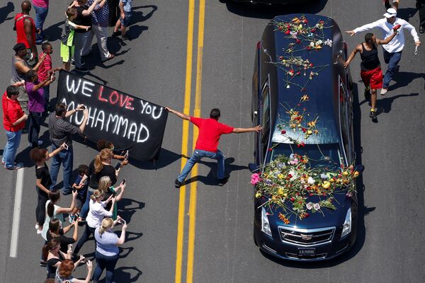Мужчина прикасается к машине с телом покойного чемпиона по боксу Мохаммеда Али во время его похоронной процессии через Луисвилль - Sputnik Литва