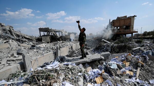 Фотоснимок сирийского солдата на фоне разрушений от американских военных ударов, архивное фото - Sputnik Литва