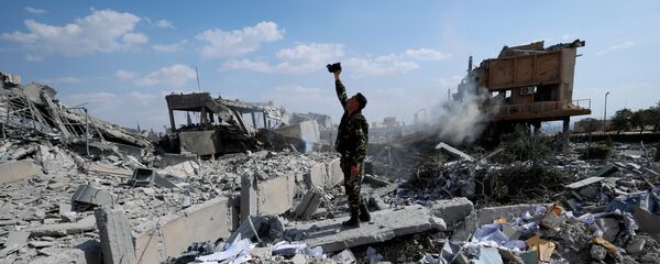 Фотоснимок сирийского солдата на фоне разрушений от американских военных ударов, архивное фото - Sputnik Литва