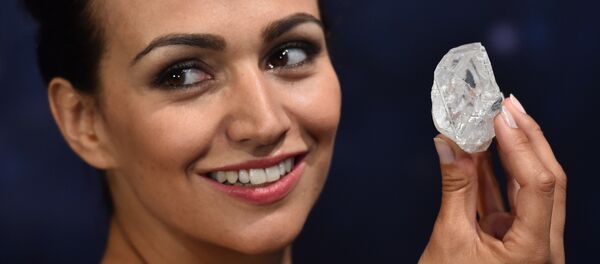 Модель позирует с неограненным алмазом в 1109 карат алмазов под названием 'Lesedi La Rona' во время аукциона Sotheby's Модель позирует с неограненным алмазом в 1109 карат алмазов под названием 'Lesedi La Rona' во время аукциона Sotheby's - Sputnik Lietuva