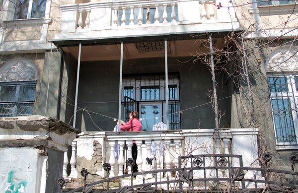 Центр города. Женщина развешивает белье на балконе старинной усадьбы - Sputnik Литва
