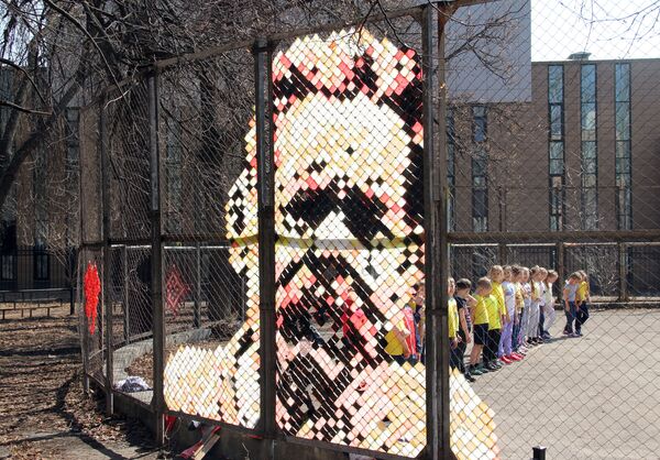Портрет Максима Горького, выполненный из полосок клейкой ленты на скучной сетке забора спортивной площадки - Sputnik Литва