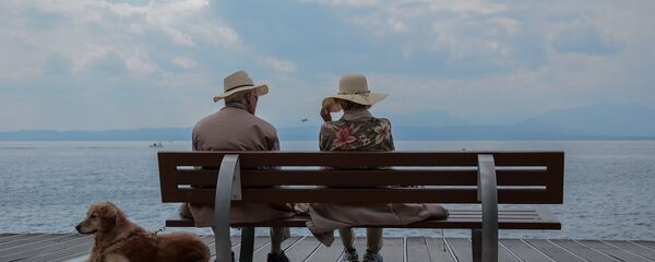 Пожилые люди на берегу с собакой, архивное фото Пожилые люди на берегу с собакой, архивное фото - Sputnik Литва