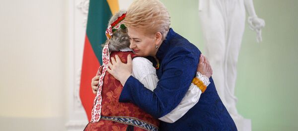 Президент Литвы Даля Грибаускайте обнимает кого-то в национальном литовском костюме Президент Литвы Даля Грибаускайте обнимает кого-то в национальном литовском костюме - Sputnik Lietuva