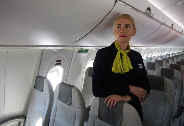 Стюардесса в салоне самолета Bombardier CS300 латвийской авиакомпании airBaltic - Sputnik Литва