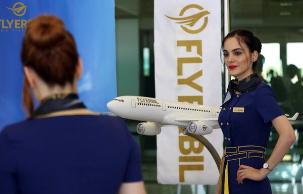Стюардесса авиакомпании Fly Erbil позирует у модели самолета в международном аэропорту Erbil в Ираке - Sputnik Литва