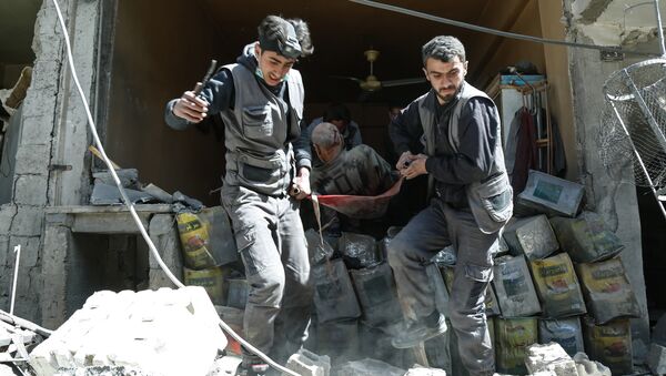 Члены Белых касок выносят раненого из-под завалов в Думе, Сирия, архивное фото - Sputnik Литва
