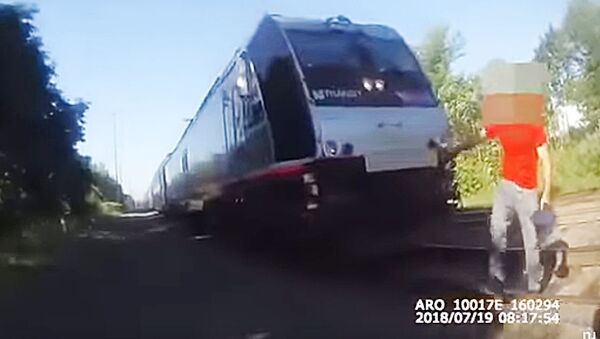 В США полицейский спас человека от поезда за мгновение до столкновения - Sputnik Lietuva