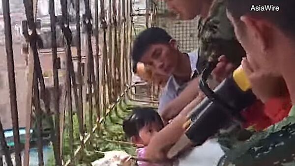 В Китае пожарные спасли девочку, застрявшую в балконной решетке - Sputnik Литва