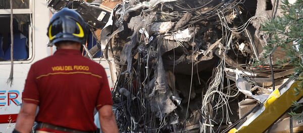 Пожарный работает на месте аварии двух пассажирских поездов южнее деревни Карато в Италии - Sputnik Литва