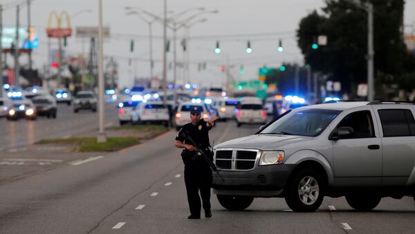 Полицейский блокирует проезд неподалеку от места преступления в Бутон-Руж, штат Луизиана, США - Sputnik Литва