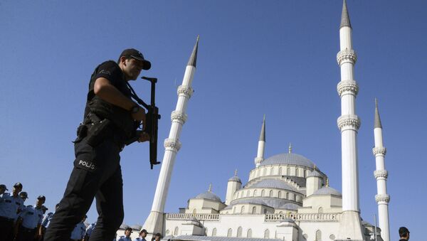Вооруженный офицер турецкой полиции в мечети Коджатепе в Анкаре стоит на страже во время церемонии похорон жертв неудачного госпереворота 15 июля - Sputnik Литва