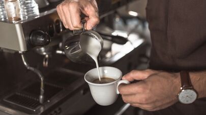 Бариста делает кофе в кафе