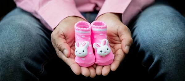 Мужчина держит детские носочки - Sputnik Литва