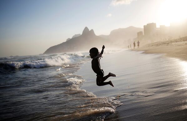 Мальчик прыгает на пляже Ипанема в Рио-де-Жанейро, Бразилия - Sputnik Lietuva