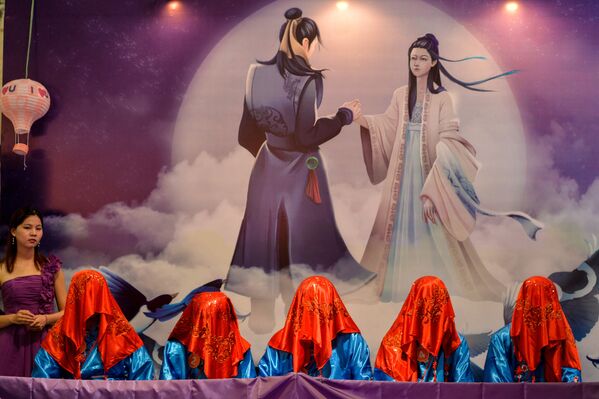 Китайские мужчины, покрытые платками, во время конкурса, в котором их невесты должны их отгадать во время Цисицзе — китайского Дня святого Валентина в Шанхае - Sputnik Литва
