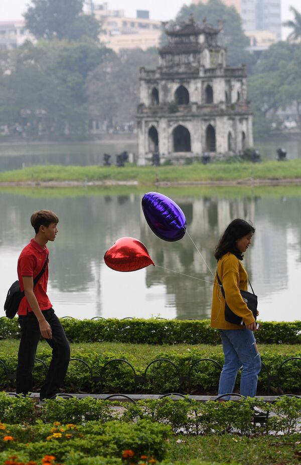 Пара с воздушными шарами в форме сердца в парке на День святого Валентина в Ханое, Вьетнам - Sputnik Lietuva