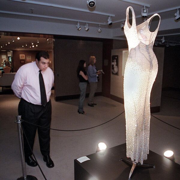 Мужчина азглядывает платье С Днем рождения мистер президент в аукционном доме Кристис в нью-Йорке, США - Sputnik Литва