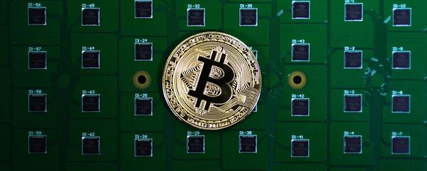 Сувенирная монета биткоина на фоне электрических плат, архивное фото - Sputnik Литва