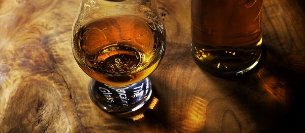 Бутылка крепкого алкоголя с фужером, архивное фото Бутылка крепкого алкоголя с фужером, архивное фото - Sputnik Литва