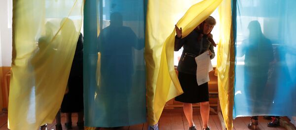 Женщина выходит из кабины для голосования на избирательном участке во время президентских выборов в Украине в Космаче - Sputnik Литва