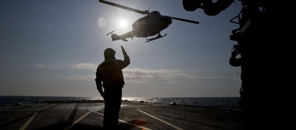 Итальянский военнослужащий обеспечивает взлет вертолета во время учений НАТО в Черном море, архивное фото - Sputnik Литва