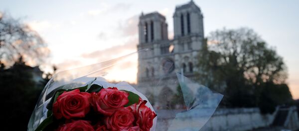 Букет роз на фоне собора Парижской богоматери, пострадавшего от пожара, 17 апреля 2019 года Букет роз на фоне собора Парижской богоматери, пострадавшего от пожара, 17 апреля 2019 года - Sputnik Литва