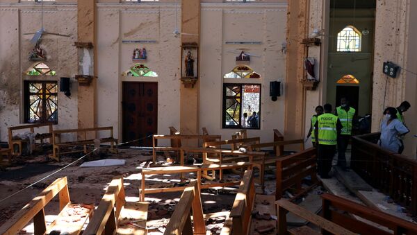 Сотрудники полиции работают на месте взрыва у католической церкви Св. Себастьяна в Негомбо, Шри Ланка, 22 апреля 2019 года - Sputnik Литва