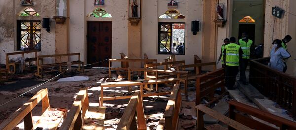 Сотрудники полиции работают на месте взрыва у католической церкви Св. Себастьяна в Негомбо, Шри Ланка, 22 апреля 2019 года - Sputnik Литва